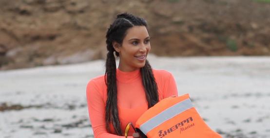 Kim Kardashian w cienkiej różowej sukience na plaży